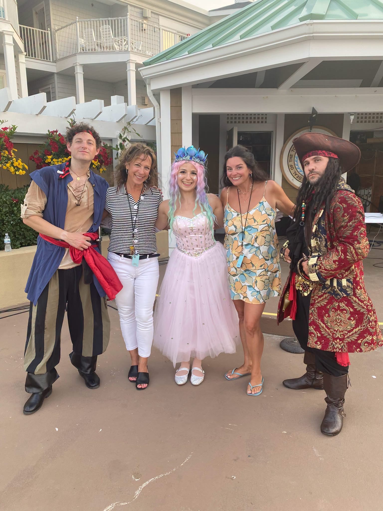 Costumed princess and pirate performers posing with guests outdoors