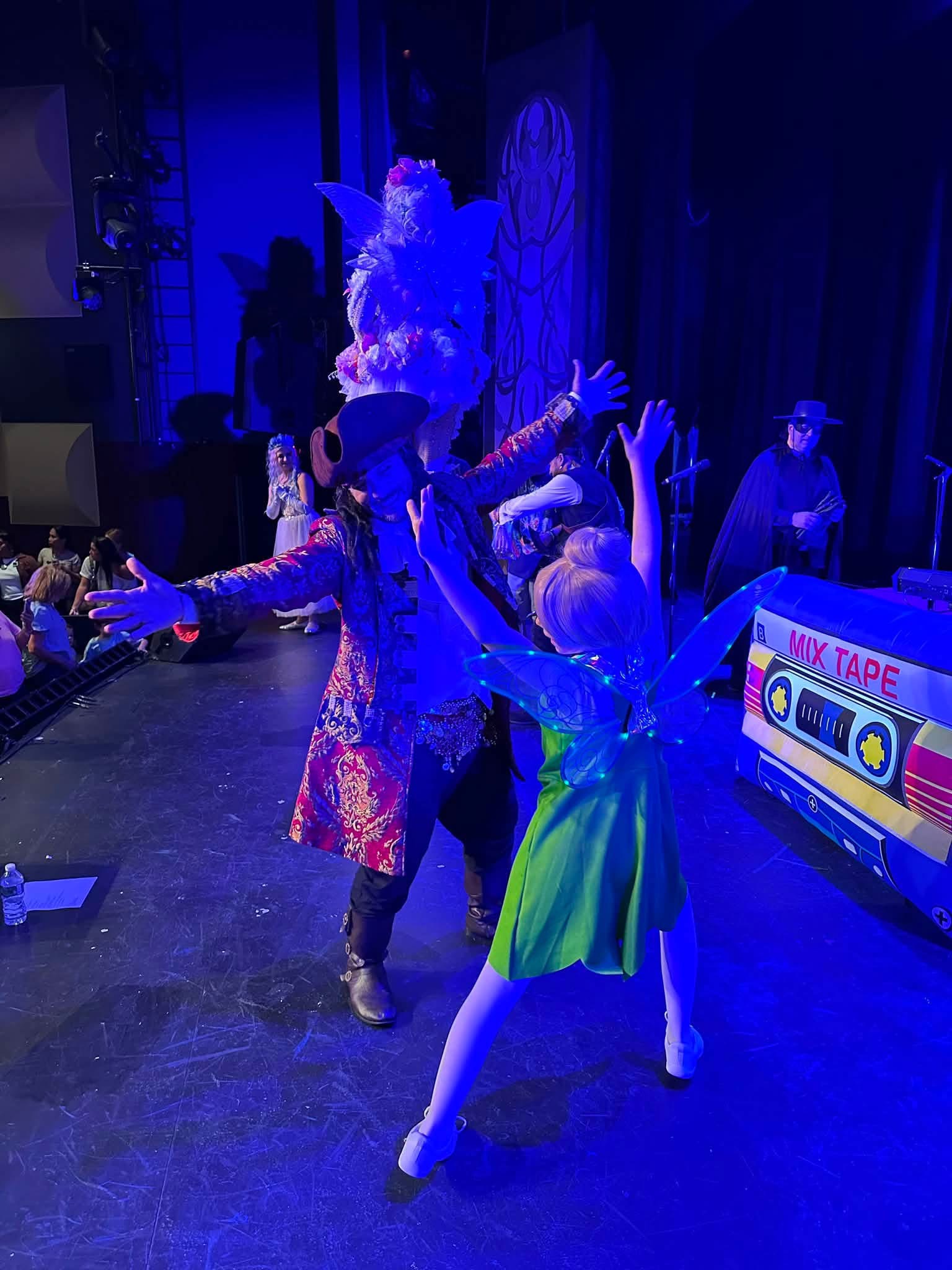 Pirate and fairy performers dancing together on stage
