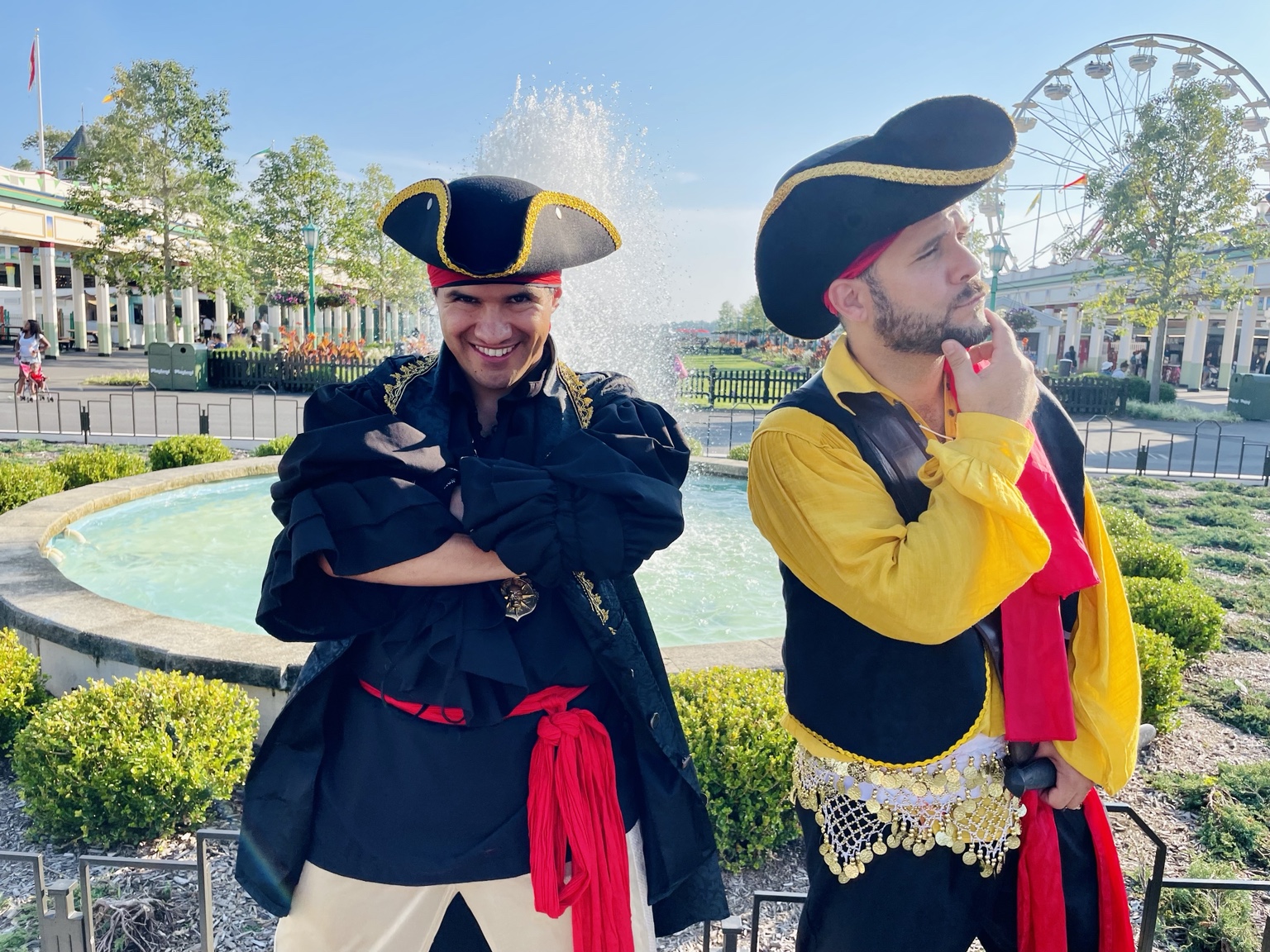 Two colorful pirate performers posing by a fountain